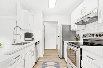 A kitchen with white cabinets and stainless steel appliances